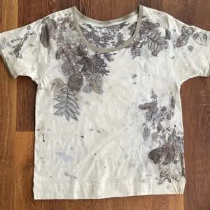 A white shirt with brown and grey leaves on it.