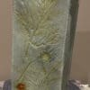 A tall vase with some leaves on it