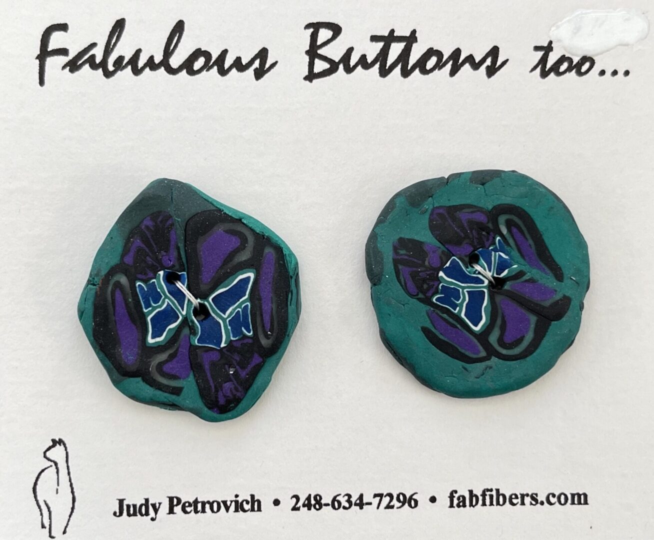 A pair of buttons with purple and blue flowers on them.