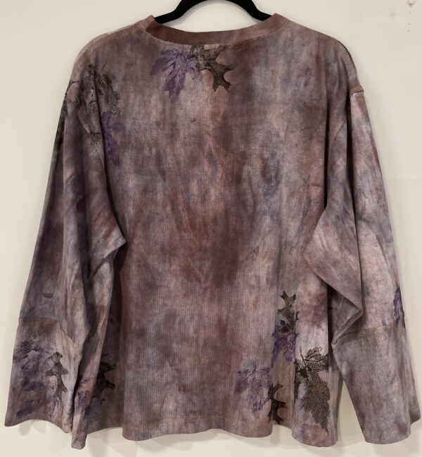 A long sleeve shirt with purple and black paint on it.