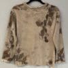 A sweater with brown flowers on it