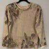 A beige sweater with brown flowers on it.
