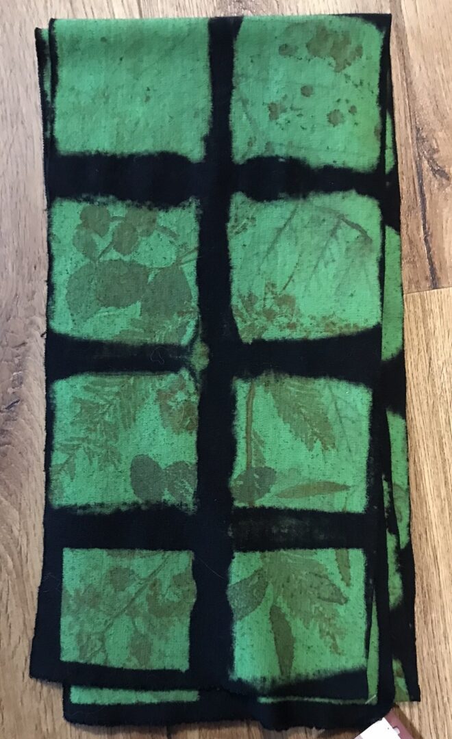 A green and black scarf on the floor
