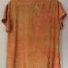 A brown shirt with some green paint on it