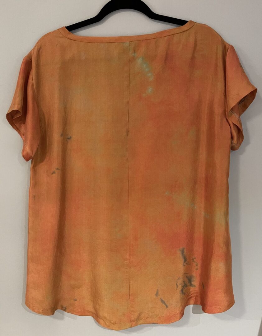 A brown shirt with some green paint on it