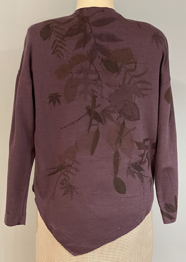 A purple sweater with brown leaves on it.