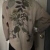 A person wearing a jacket with leaves on it.