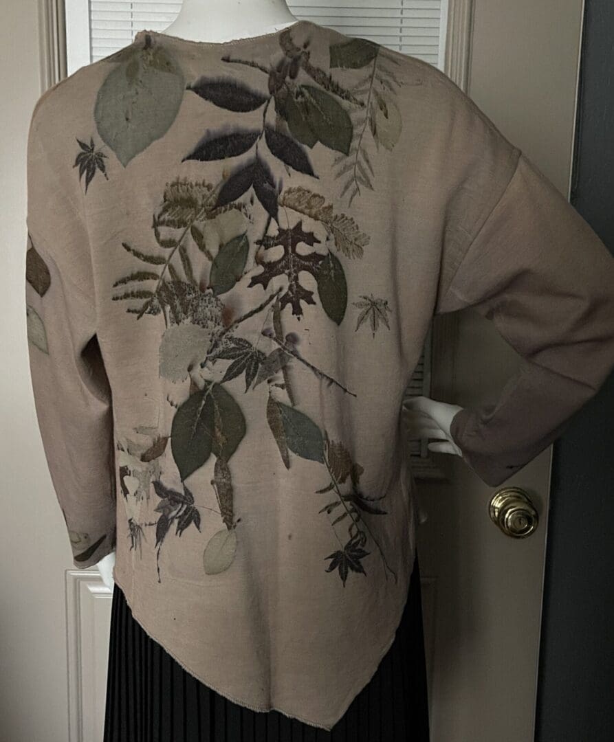 A person wearing a jacket with leaves on it.