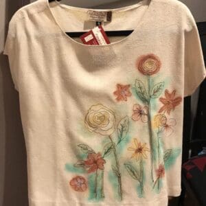 A white shirt with flowers painted on it.