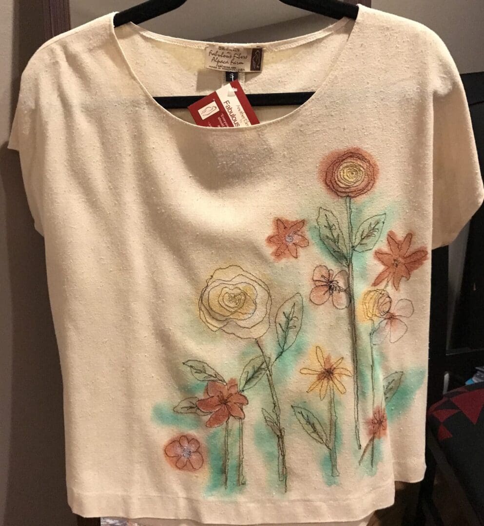 A white shirt with flowers painted on it.