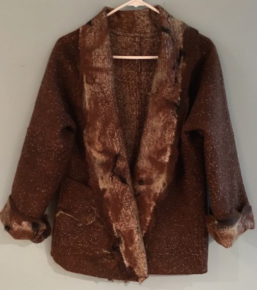 A brown coat with fur on it hanging from a clothes line.