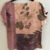 A pink and purple floral print top is hanging on the wall.