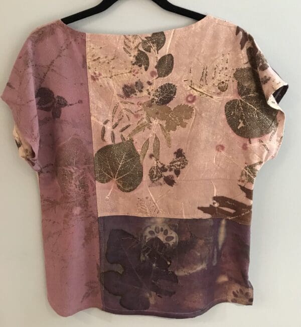 A pink and purple floral print top is hanging on the wall.