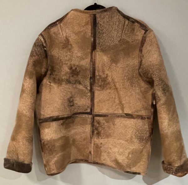 A brown jacket hanging on the wall