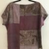 A purple and brown shirt hanging on a wall.