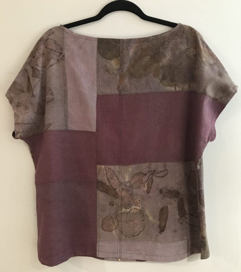 A purple and brown shirt hanging on a wall.