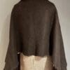 A brown shawl is draped over the back of a mannequin.