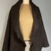 A brown shawl is draped around the neck of a mannequin.