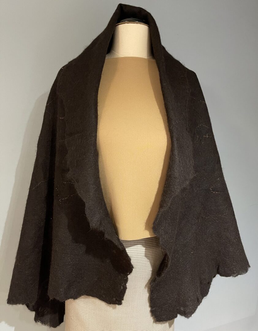 A brown shawl is draped around the neck of a mannequin.