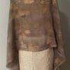 A brown and beige poncho draped over the shoulders of a mannequin.