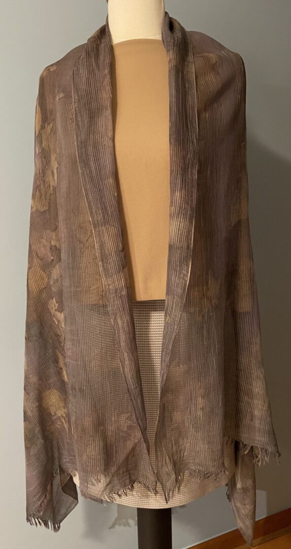 A brown and tan colored long vest with a large pocket.
