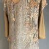 A beige and brown dress with leaves on it.