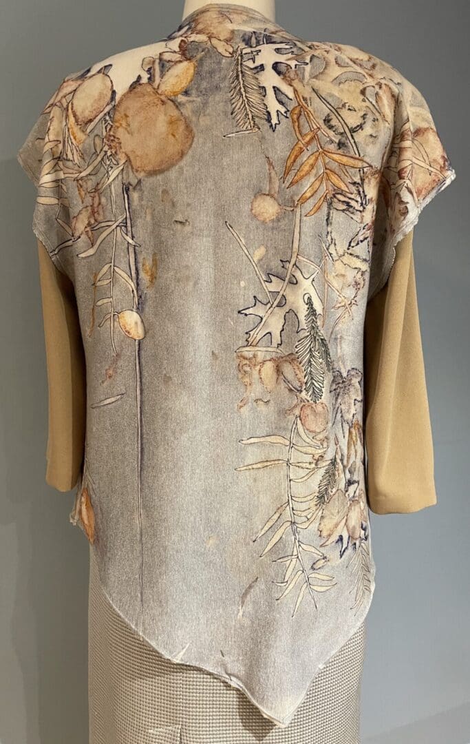 A beige and brown dress with leaves on it.