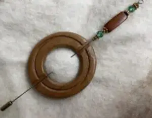 A wooden ring with beads hanging from it.