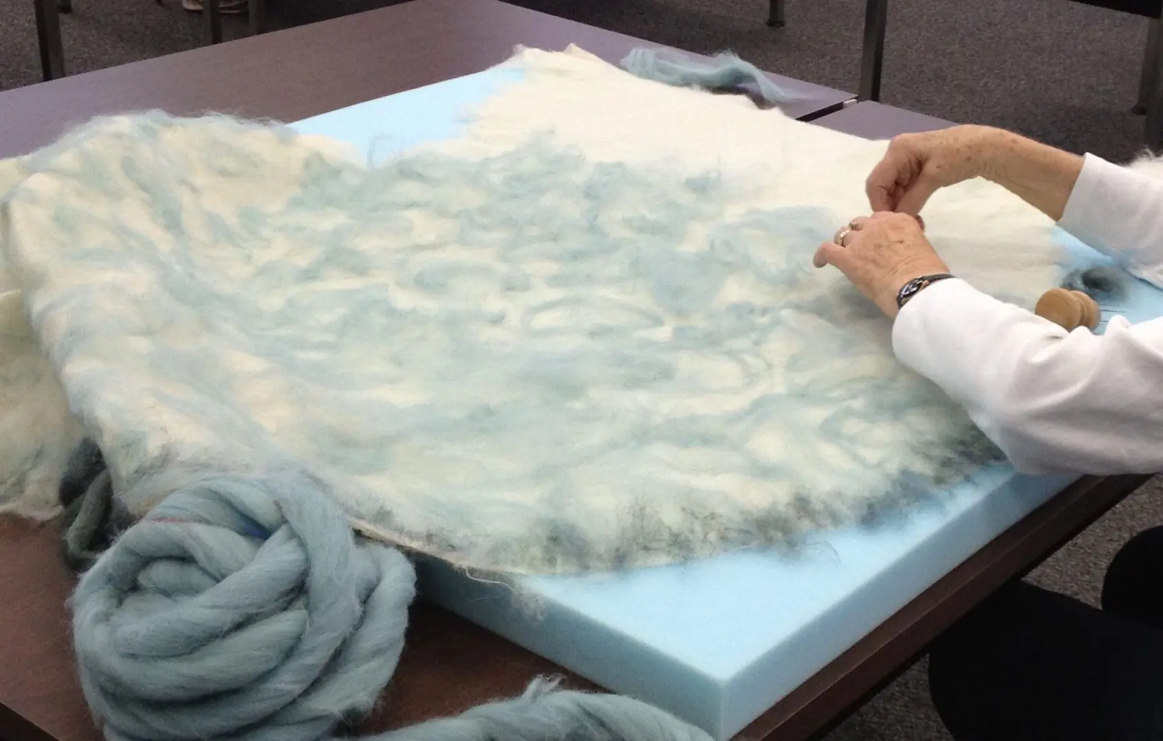 A person is working on a fur rug.