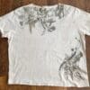 Beige t-shirt with botanical print and stains.