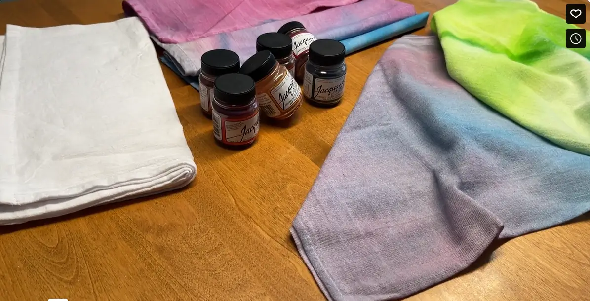 A wooden table with towels and small bottles kept on it.